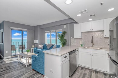 Kitchen with decorative backsplash, wood finish floors, white cabinets, open floor plan, and light stone counters