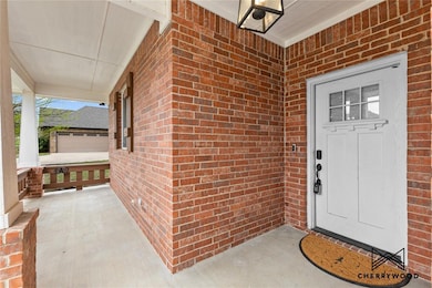 Property entrance featuring brick siding and cover
