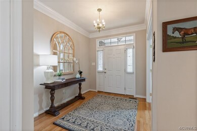 Lovely foyer entrance with crown molding and a cha
