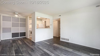 Unfurnished living room with dark wood-type flooring and a ceiling fan