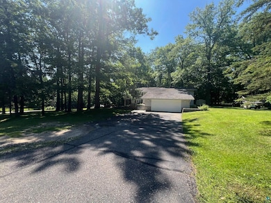 Obstructed view of property featuring asphalt driveway, a front lawn, and a garage