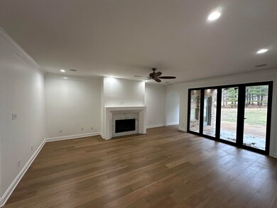 Unfurnished living room featuring crown molding, wood finished floors, a fireplace, and baseboards