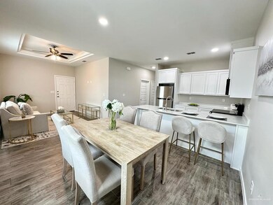Dining area with wood finished floors, visible vents, a tray ceiling, recessed lighting, and ceiling fan