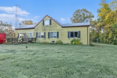 Rear view of property featuring a yard and a wooden deck