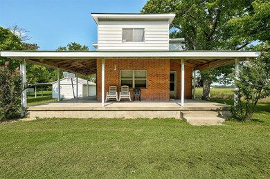 Back of property featuring a carport, an outdoor s