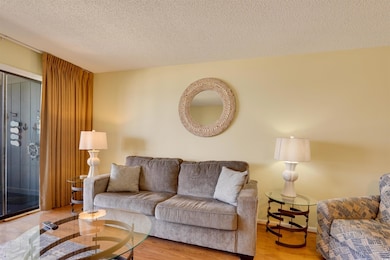 Living area featuring a textured ceiling, baseboar