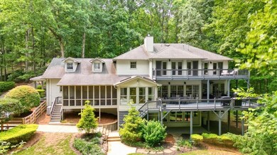 Rear view of house featuring a screened in porch, a sunroom, a upper balcony, and a large main level deck