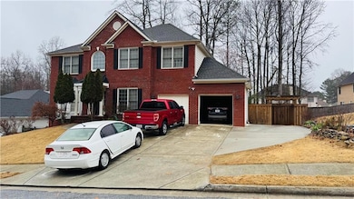 Colonial home with brick siding, concrete driveway, a shingled roof, and a garage