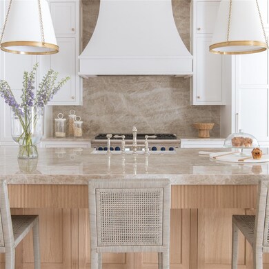 Kitchen with light stone counters, white cabinetry
