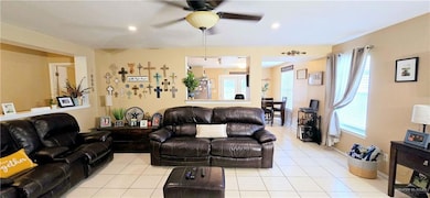 Living area with ceiling fan, light tile patterned floors, and recessed lighting