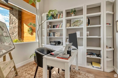 Home office with light wood-style flooring and view to front yard
