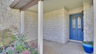 View of exterior entry with stone siding and covered porch