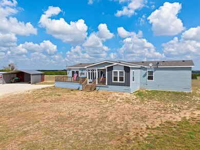View of front of home featuring a carport, board 