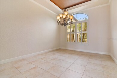 The dining room is adorned with a tray ceiling, de