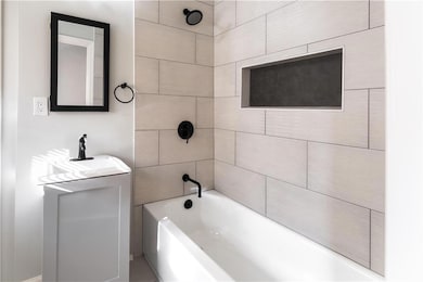 Bathroom featuring a sink and washtub / shower com