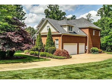 Aggregate stone driveway leads to a three car gara