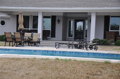 View of covered back porch looking out at the pool
