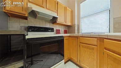 Kitchen featuring tasteful backsplash, under cabin