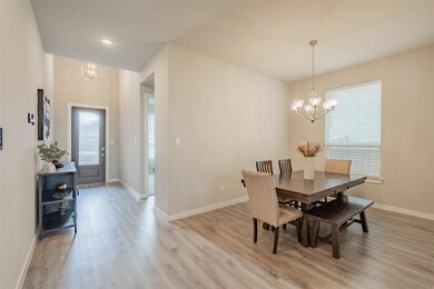 Dining room with light hardwood / wood-style floors and an inviting chandelier