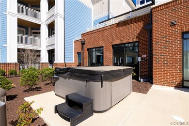 View of patio with a hot tub and a balcony