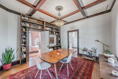 Dining room features coffered ceiling, wood floors