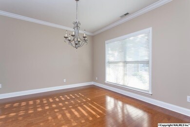 Formal dining room featuring hardwood floors, crown molding and window covering.