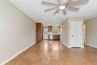 Unfurnished living room featuring ceiling fan