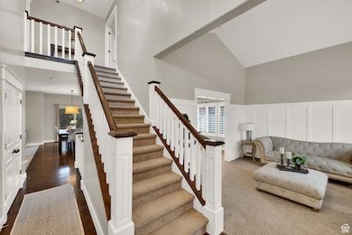 Stairs featuring high vaulted ceiling and wood finished floors