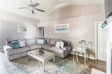 Living room with baseboards, lofted ceiling, wood 