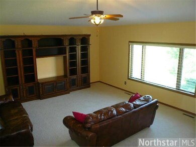 Light filled living room with celing fan and light