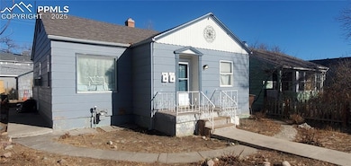 View of front of house with a shingled roof and a chimney
