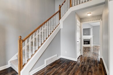 Stairs featuring a fireplace and wood-type floorin