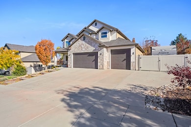 Traditional home featuring a gate, driveway, stone siding, stucco siding, and a garage