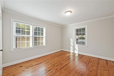 Spare room with hardwood / wood-style flooring and crown molding