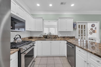 Kitchen with visible vents, a sink, stainless stee