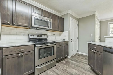 Kitchen with dark brown cabinetry, decorative back