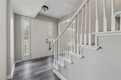 Entryway with stairway, baseboards, and wood finis