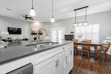 Kitchen with ceiling fan, sink, white cabinetry, d