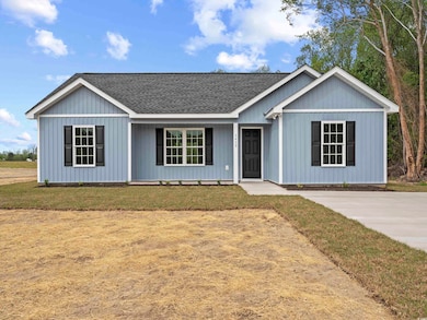 View of front of house featuring a shingled roof and a front yard