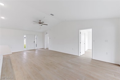 Unfurnished living room featuring lofted ceiling,