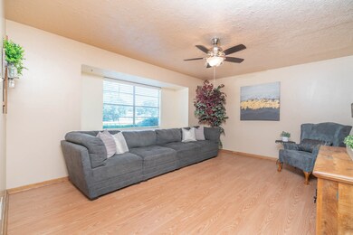 Directly opposite the dining room, this inviting family room showcases a neutral paint selection, easy to care for wood-look laminate flooring, a lighted ceiling fan, and a deep set front facing window with 2 inch blinds and a charming window seat.