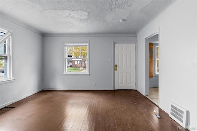 Empty room featuring hardwood / wood-style flooring and a textured ceiling
