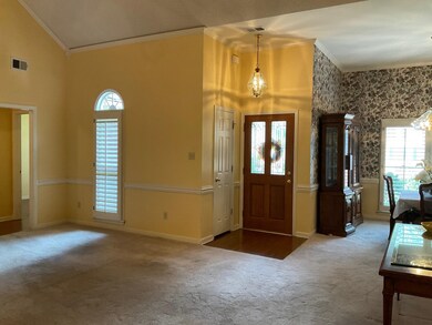 Carpeted foyer entrance featuring high vaulted cei