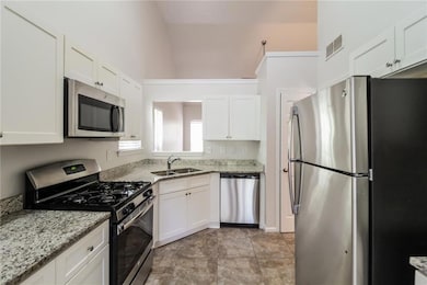 Kitchen with light stone counters, stainless steel
