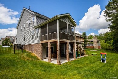 Back of the home with view of the walk-out basement and lower level patio, screened porch and deck.  The back yard is fenced with black aluminium that looks like wrought iron.  What a great area for the family and pets to play!