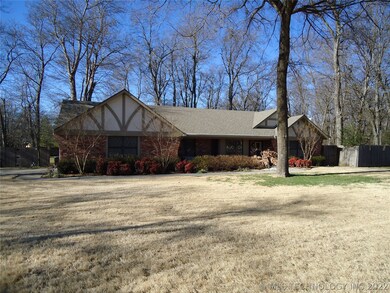 Extensive landscaping framed with towering trees.