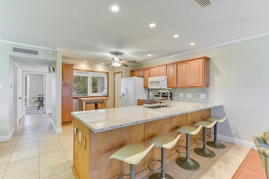 Kitchen with visible vents, a sink, backsplash, w