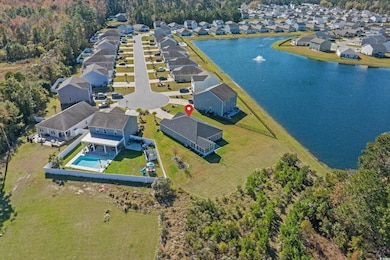 Aerial view of residential area with a nearby body of water and a pool
