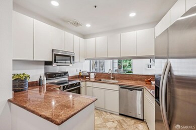 The open kitchen features generous counter space, sleek granite surfaces, stainless steel appliances, and plenty of storage.