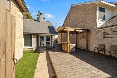Outdoor area featuring a zero lot line design ideal for entertaining, complete with artificial turf on one side and a custom deck with a built-in bar on the other.